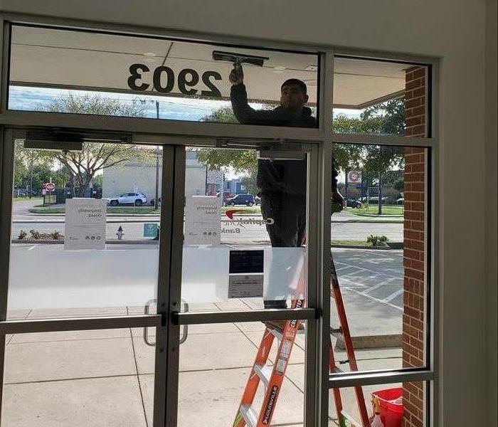 Technician Cleaning the Outside of a Commercial Building Window