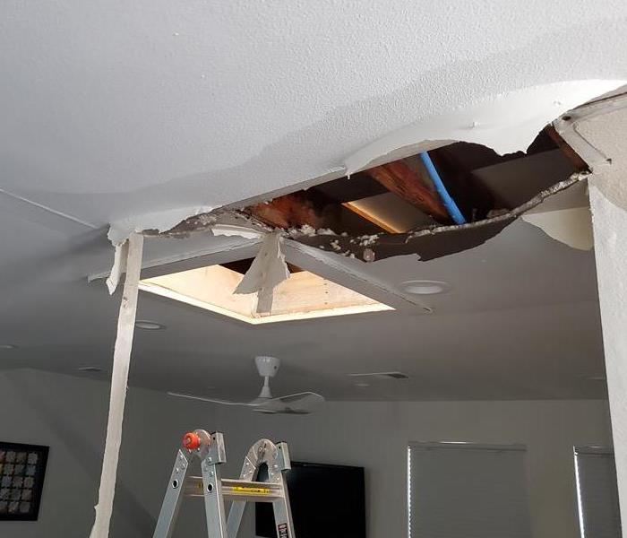 Ceiling Drywall damage with a big hole and drywall tape hanging down