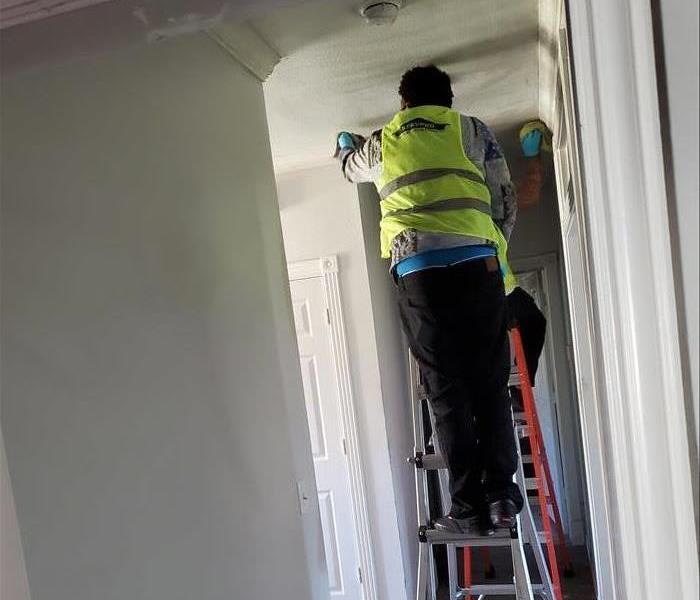 SERVPRO Employee Cleaning Building Ceiling After a Fire